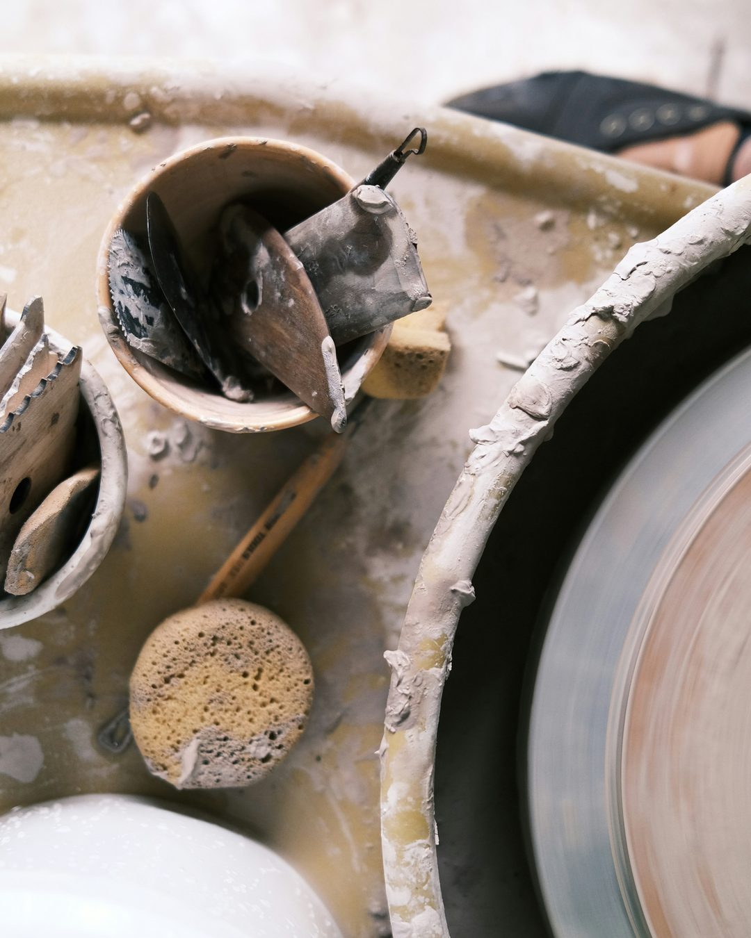 Hands shaping clay on a potter's wheel